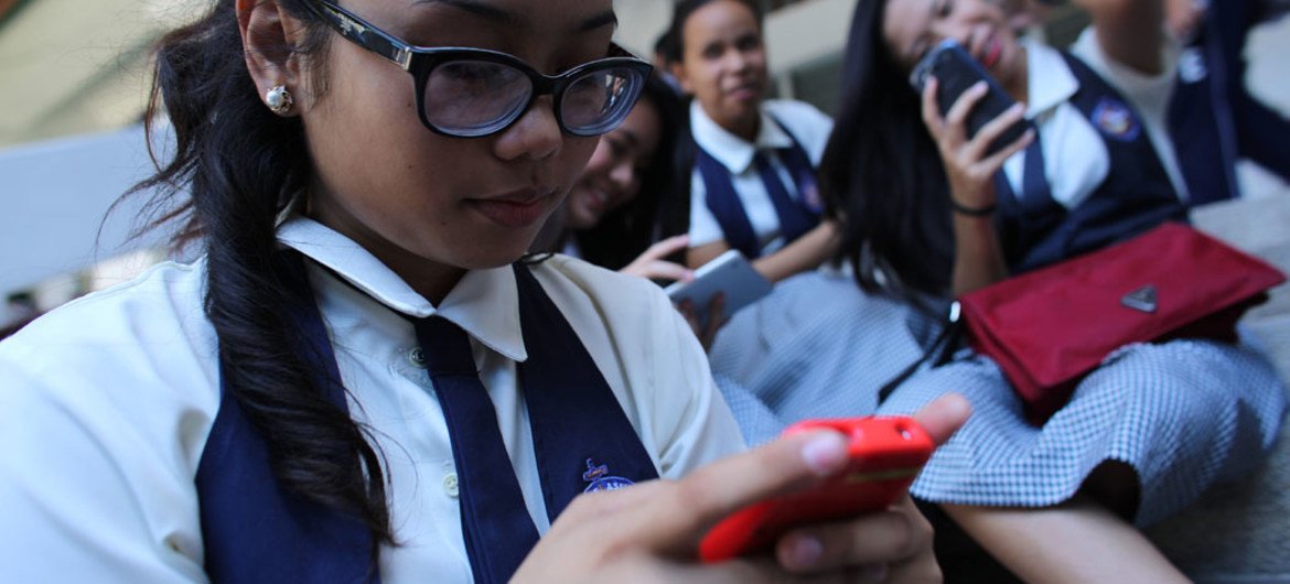 Uma estudante da Escola São Francisco de Assis e outras meninas verificam seus smartphones depois das aulas na cidade de Cebu, em Central Visayas, Filipinas
