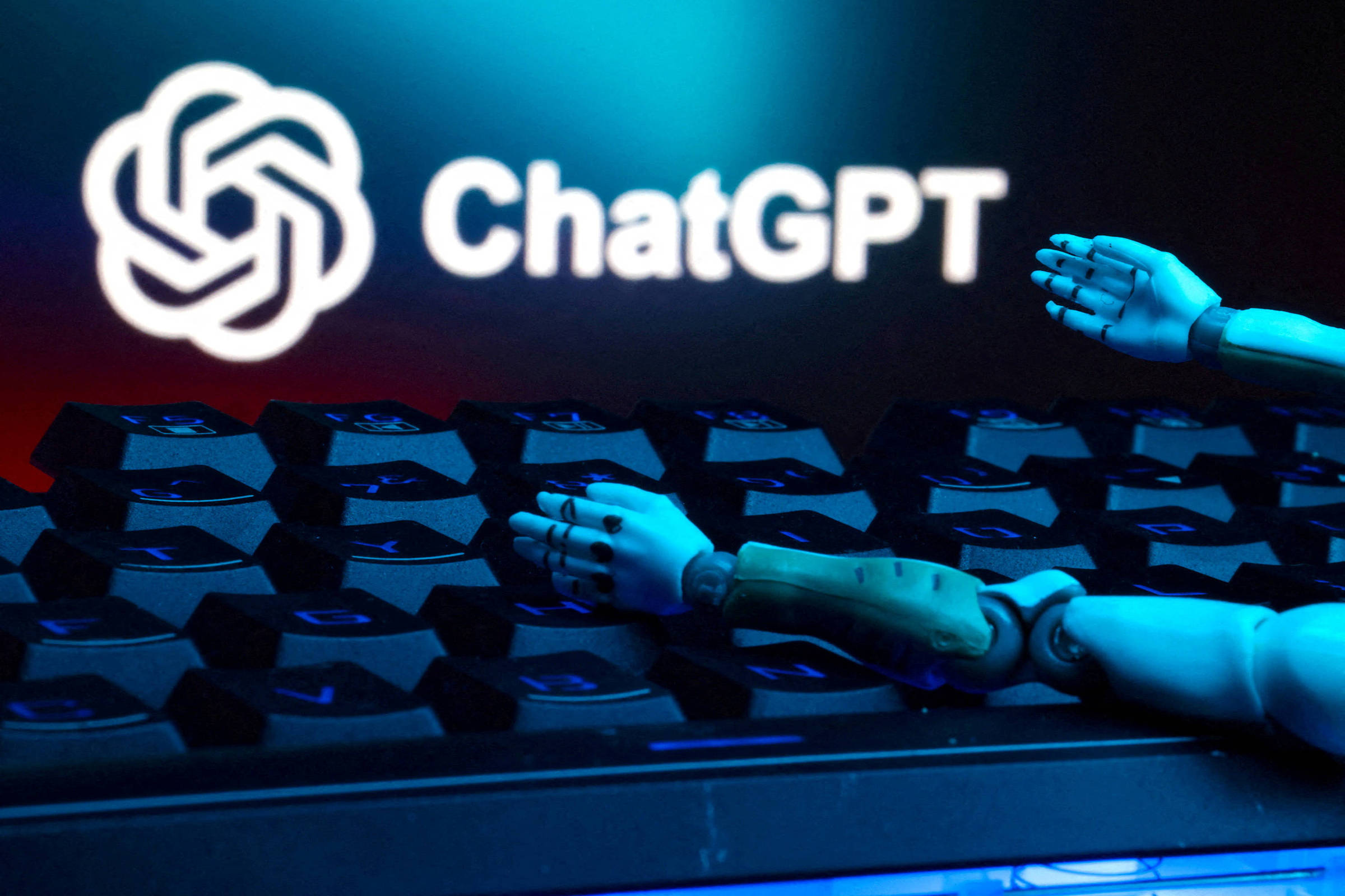 A imagem mostra um teclado de computador com algumas teclas em destaque. Em cima do teclado, há um braço robótico que parece estar se apoiando. Ao fundo, está o logotipo do ChatGPT, iluminado em uma cor clara, contrastando com um fundo azul escuro.