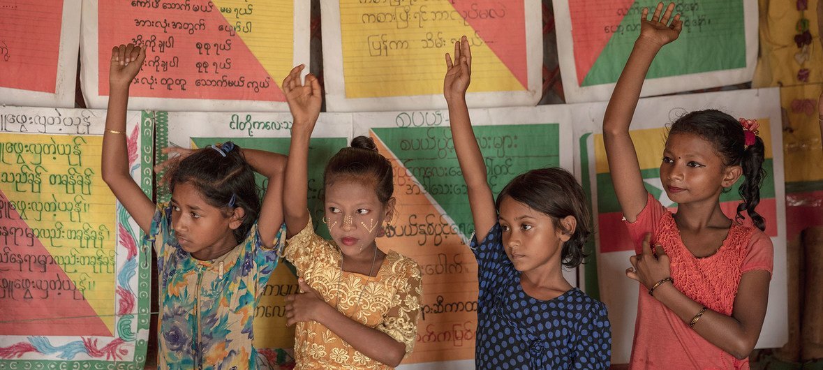 Crianças levantam as mãos para responder a uma pergunta em sala de aula em um espaço de aprendizagem da Unicef em Cox's Bazar, Bangladesh, em 8 de julho de 2019