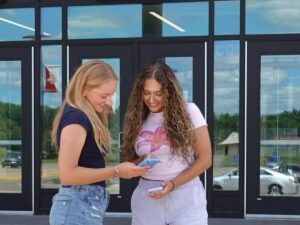 Olivia Kanavati, à esquerda, e Evangeline Fuentes, à direita, são membros do clube de bem-estar digital da escola e dizem que apóiam uma nova lei estadual que exigirá que as empresas de mídia social adicionem rótulos de alerta de saúde mental a seus sites a partir do próximo ano. A dupla posou para fotos fora da escola em 17 de julho de 2025.