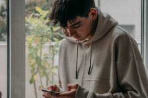 Teenage boy at home looking at mobile phone.