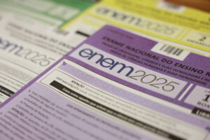 Cartões de inscrição do Exame Nacional do Ensino Médio (ENEM) 2025 dispostos em camadas, com destaque para o cartão roxo em primeiro plano. Cada cartão exibe o logo