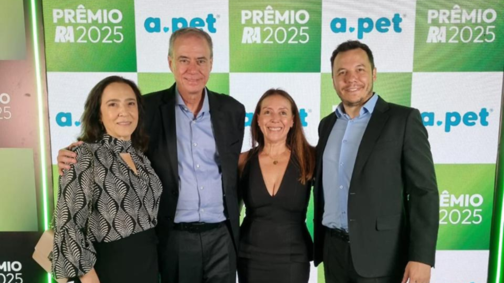 Equipe da APet posa durante a cerimônia do Prêmio Reclame AQUI 2025 em São Paulo. Da esquerda para a direita: Regina Gênova (CFO), Luiz Gênova (CEO), Andrea Valle (CXO) e Leonardo Raphaelli (COO), com o painel oficial do prêmio ao fundo.