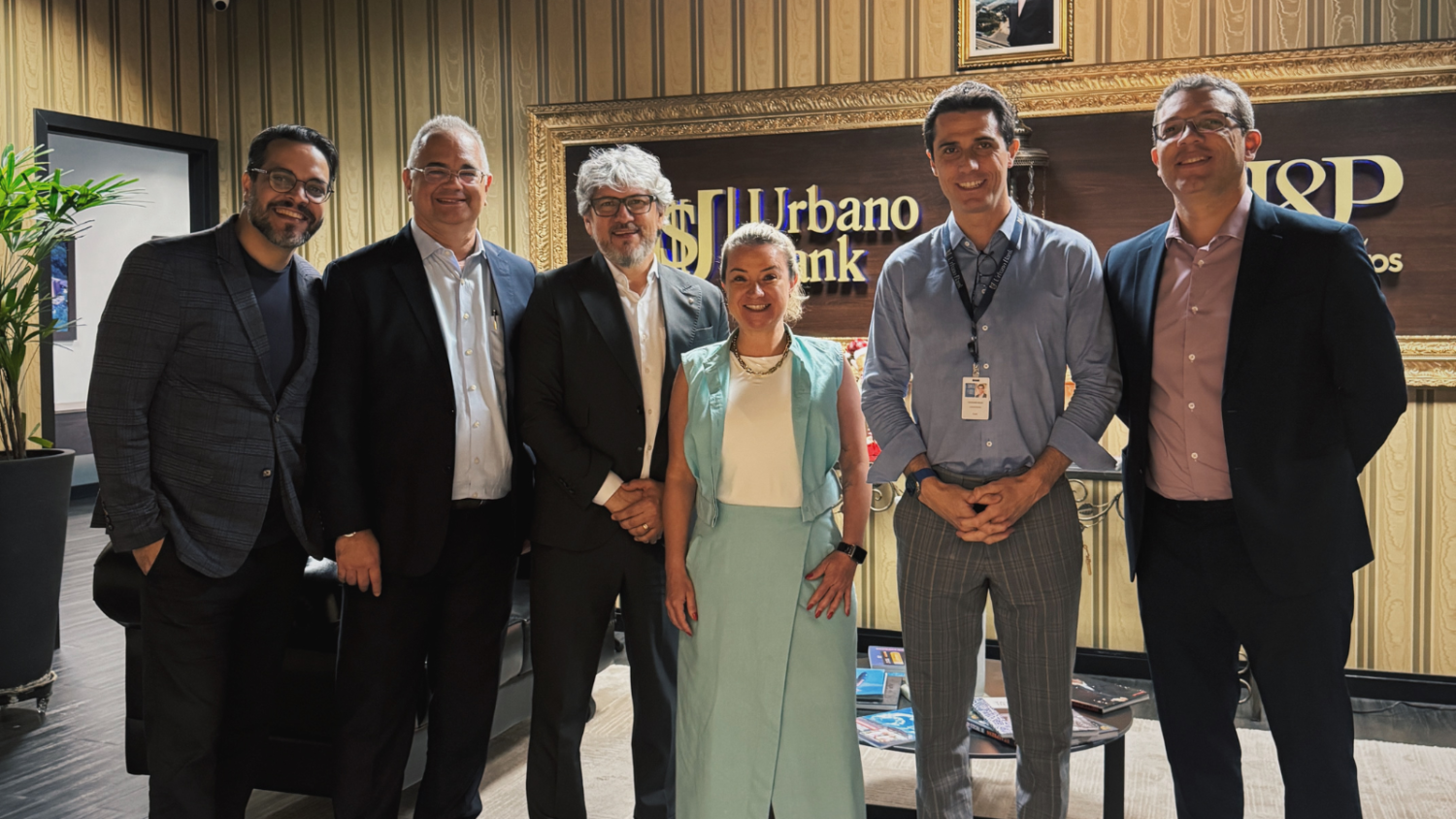 Grupo formado por representantes da B2WE, Sescon-RJ, Sescon-PI, PRNews e executivos do Urbano Bank posando durante visita técnica à sede da instituição em São Paulo.