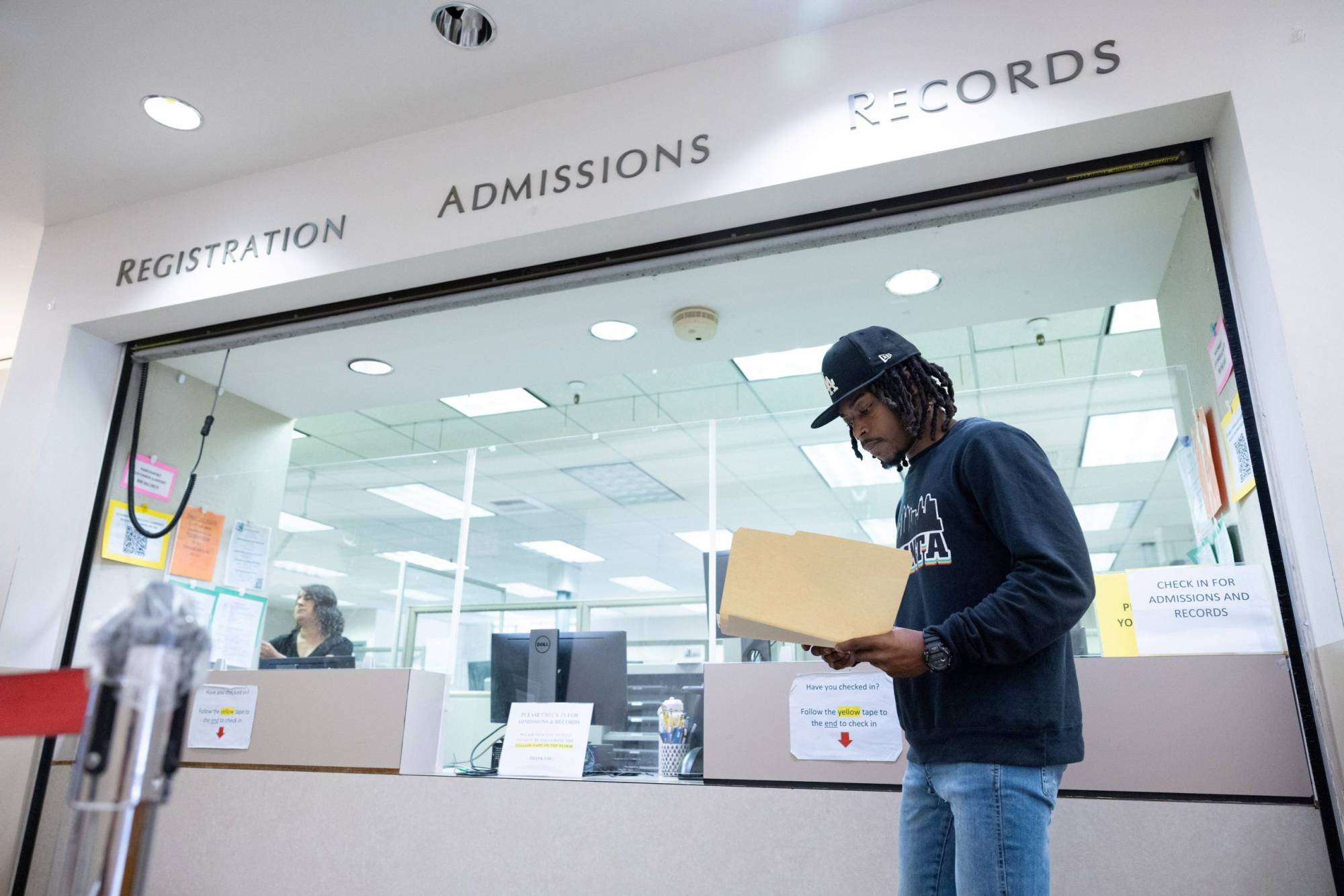 Person stands in front of a college administration window