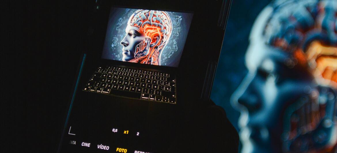 Um smartphone que exibe um cérebro digital na tela, colocado em cima de um laptop, simbolizando inteligência artificial e tecnologia de próxima geração.