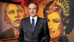 Ricardo Bellino diante de obras da coleção ArtCaps feitas com cápsulas de café recicladas.