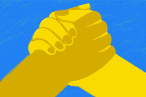 Sob um fundo azul claro surgem duas mãos, com diferentes tons de amarelo, se cumprimentando de modo firme.