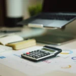 Calculadora e papéis para calcular novas taxas da Reforma Tributária.