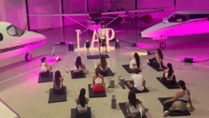 Participantes da LAP Experience realizam treino funcional em hangar com aeronaves em Campinas.