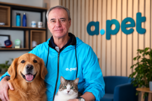 Luiz Gênova, CEO da APet, empresa de planos de saúde para cães e gatos, em ambiente corporativo, ao lado de um cachorro e um gato.